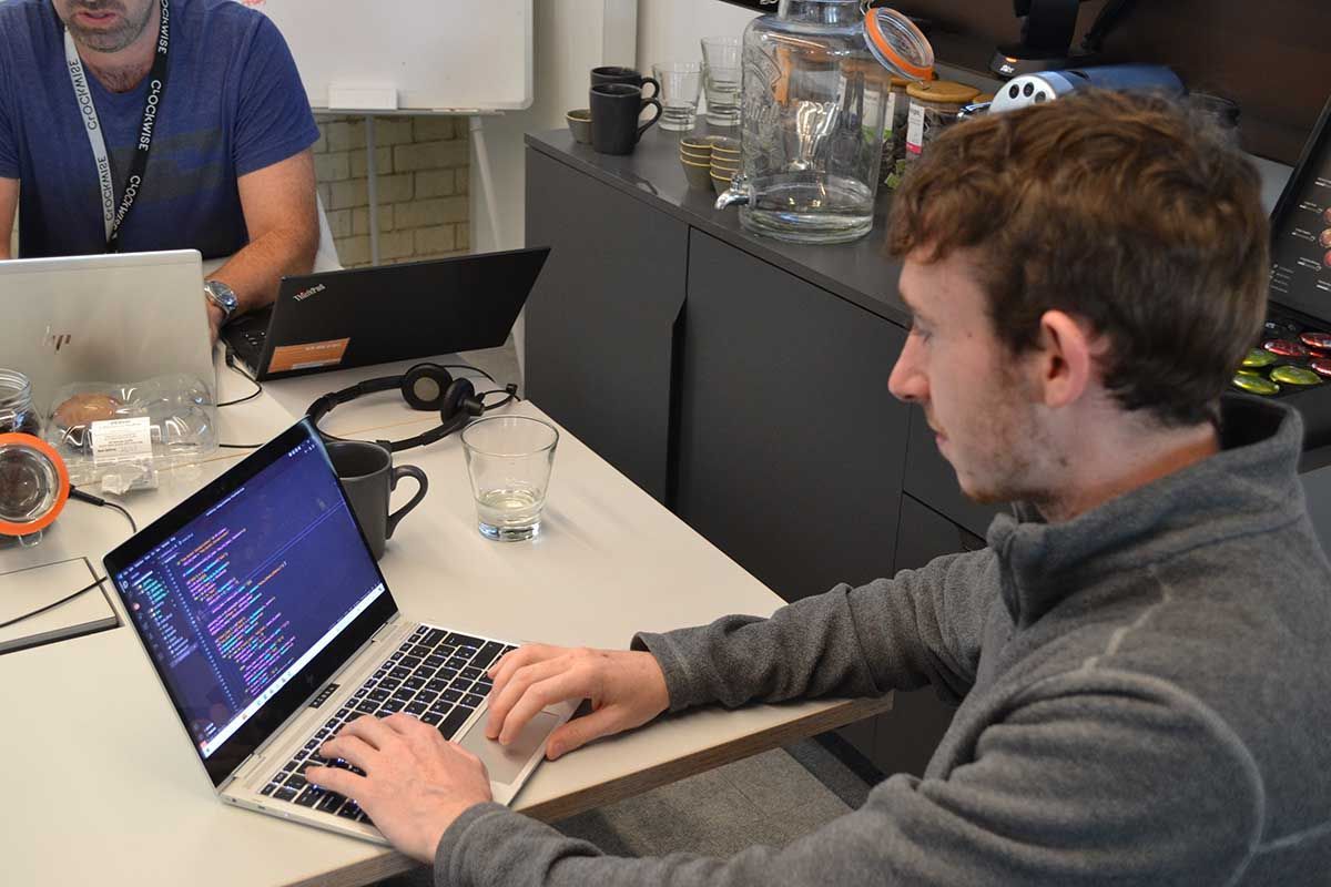 male team member writing code on a laptop